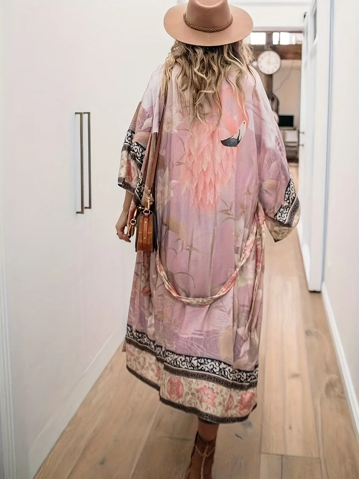 Back view of dusty rose kimono with crane print and tie belt, worn while walking down a hallway