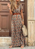Close-up of a woman in a green, orange and blue paisley print wrap dress with brown leather belt and straw bag