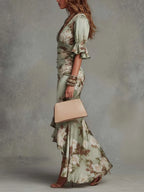 Side profile showing the ruched waist and asymmetrical high-low hem of the floral satin maxi dress