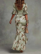 Back view highlighting the fitted bodice, flounce cuffs and mermaid-style flared skirt