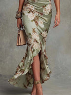 Close-up of the ruched waist and flowing asymmetrical ruffle hem of the satin dress