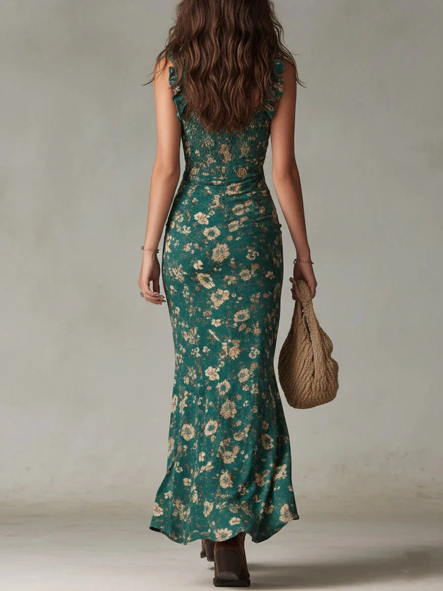 Back view of the green floral maxi dress showing the smocked bodice, ruffle shoulder straps and flowing floor-length skirt