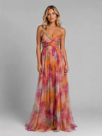 Front view of model in orange, pink and green watercolour floral maxi dress with V-neckline and crossover waist detail