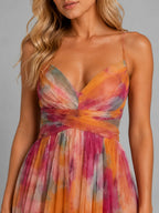 Close-up of the V-neckline, crisscross waistband and sheer tulle overlay in the orange and pink floral print