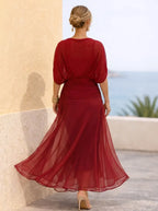 Full length view of the purple floral maxi dress with flared chiffon skirt and gold cuff bracelet