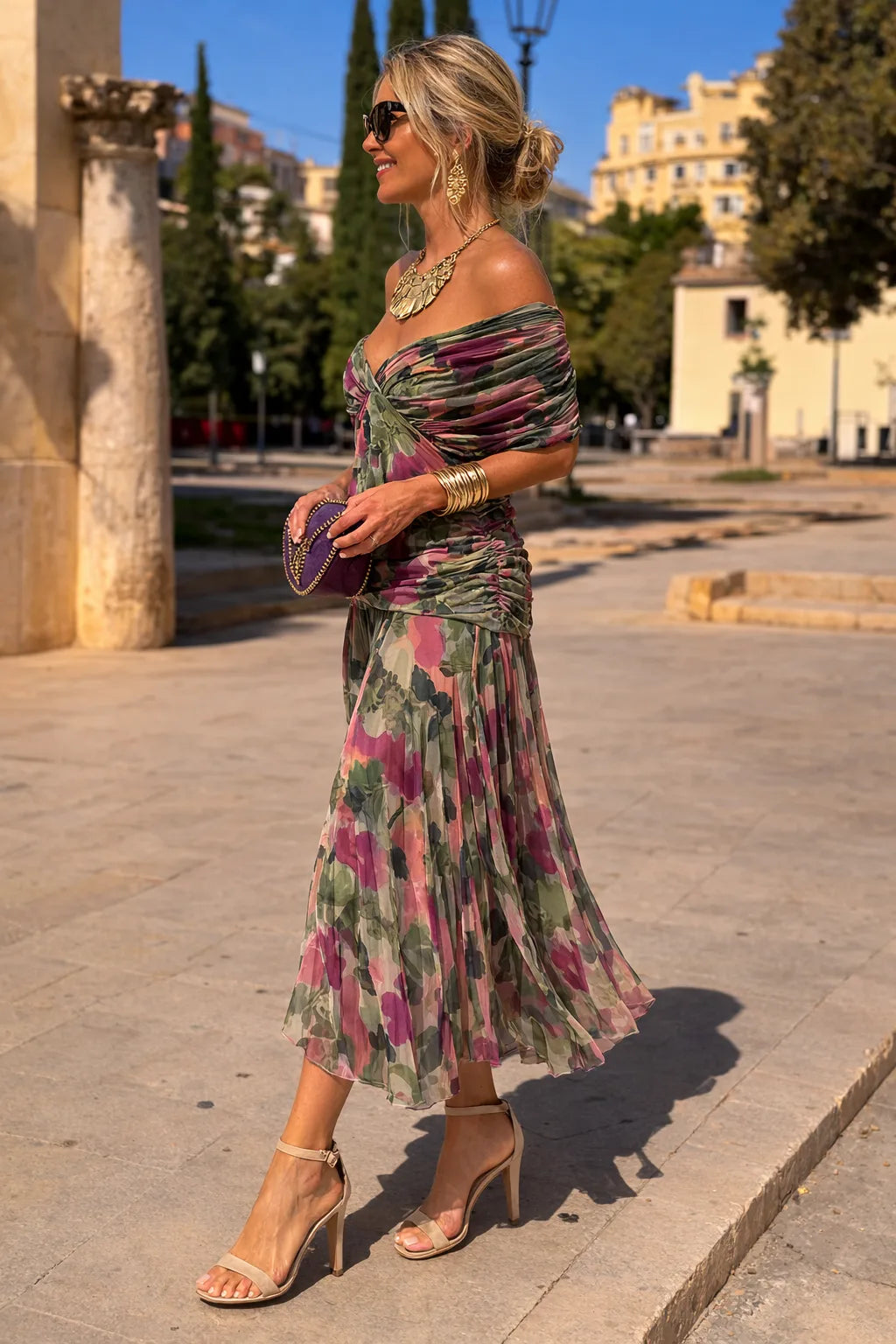 Side view of the floral off-shoulder maxi dress showing the twist front detail and flowing pleated skirt