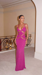 Side angle on marble stairs showing the fitted bodice and floor-length skirt of the metallic pink maxi dress