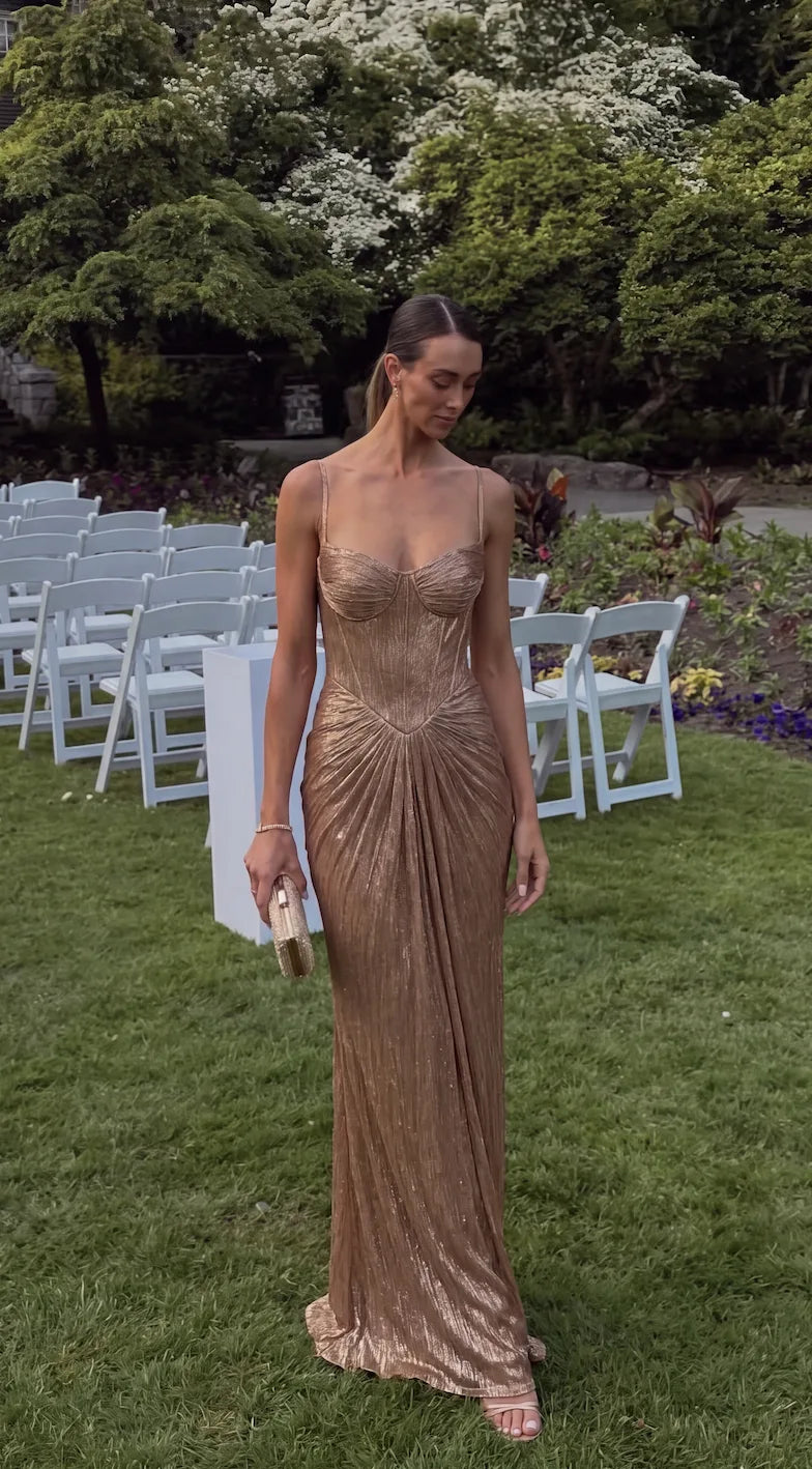 Full length front shot of gold pleated corset gown with ruched skirt detail at an outdoor garden wedding