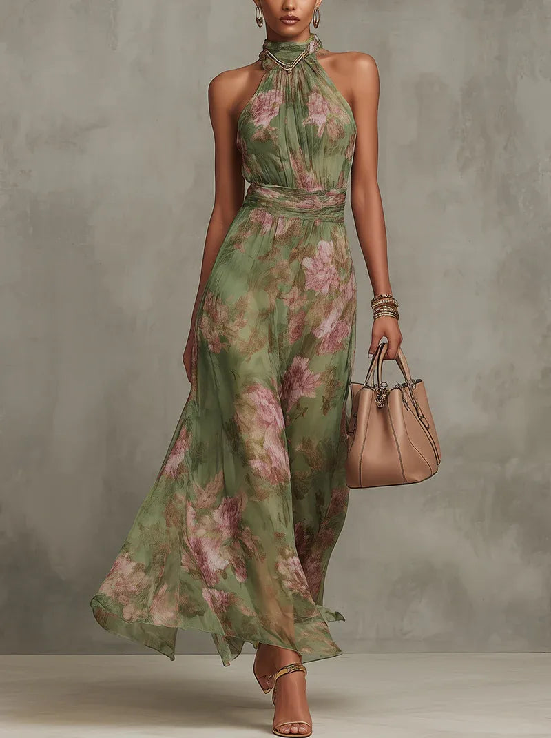 Front view of a woman walking in a green floral halter-neck maxi dress, holding a tan handbag, paired with strappy heels
