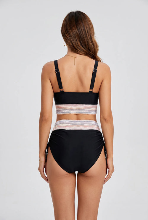 Back view showing adjustable buckle straps and high-waisted black bottoms with ruched side tie detailing