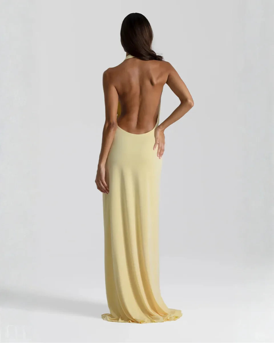 Back view of the yellow maxi dress showing the fully open backless design and flowing skirt