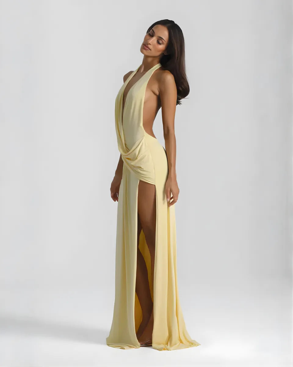 Side profile of the yellow draped maxi dress highlighting the high thigh slit and halter tie