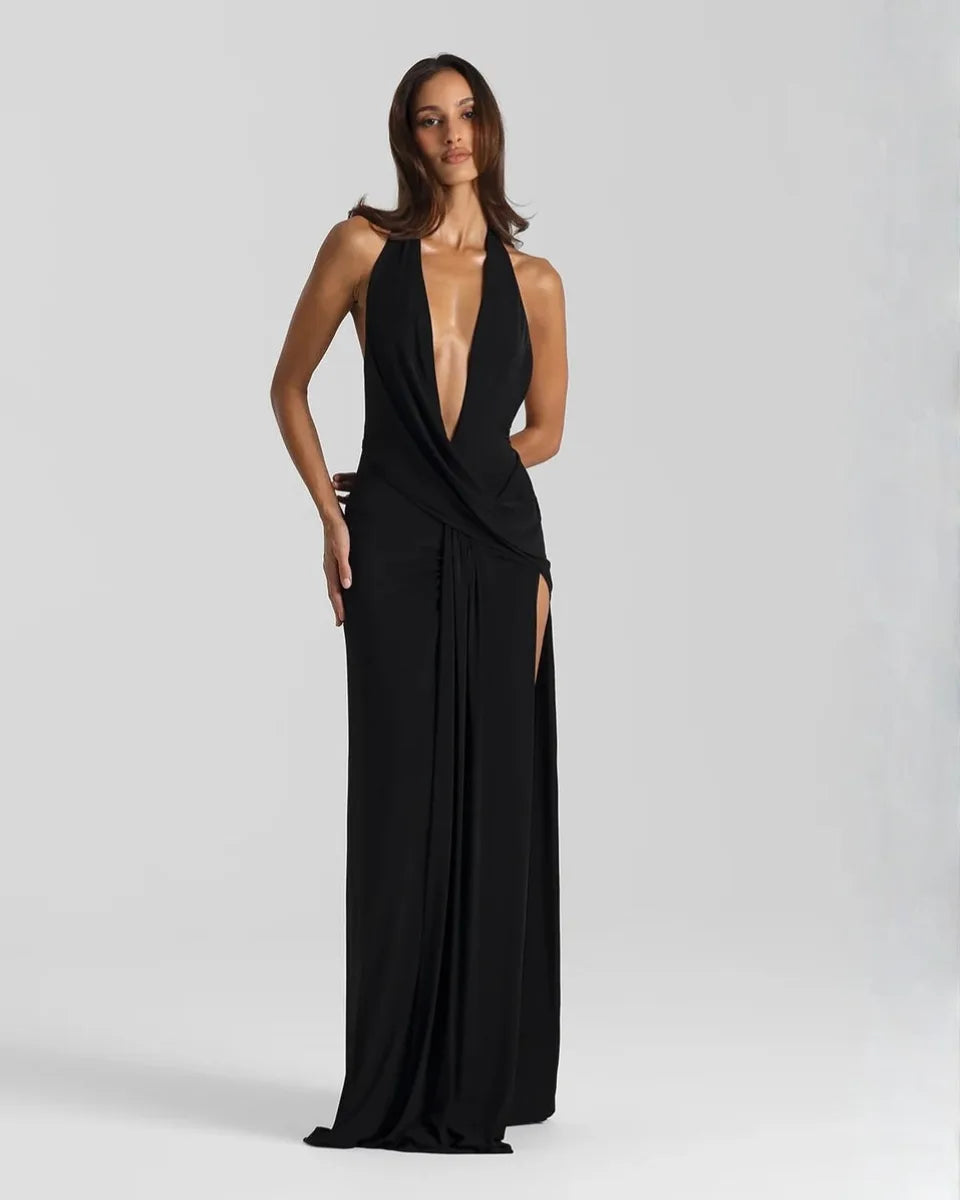 Front view of a model in a black halter neck maxi dress with plunging neckline and draped front