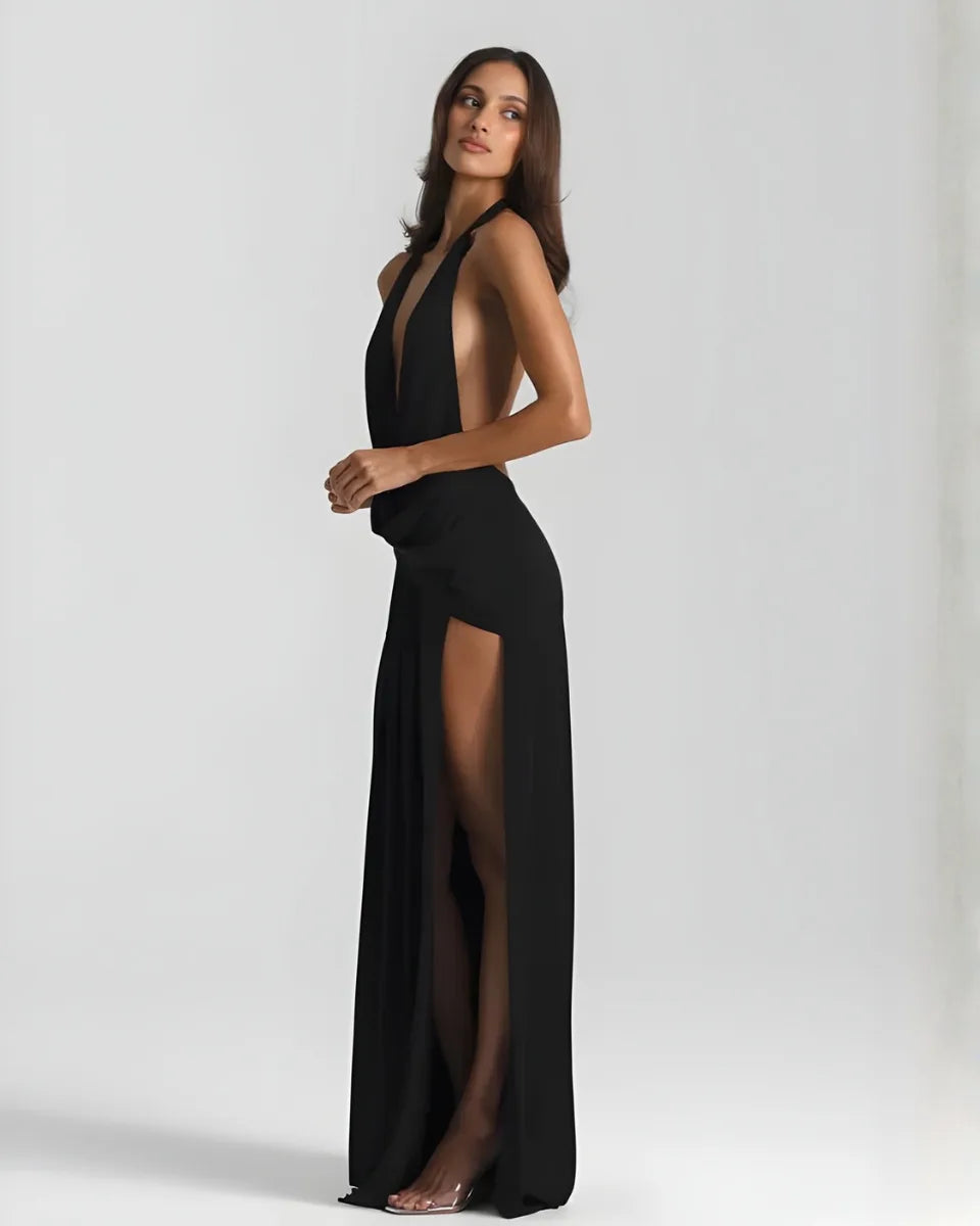 Side view of the black maxi dress showing the open side cutout and high slit with sheer fabric fall