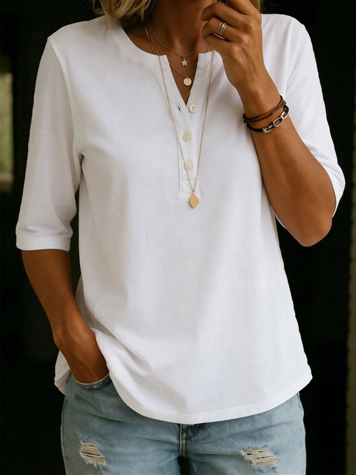 Front view of a white Henley-collar tee with four buttons, half sleeves and a curved hem