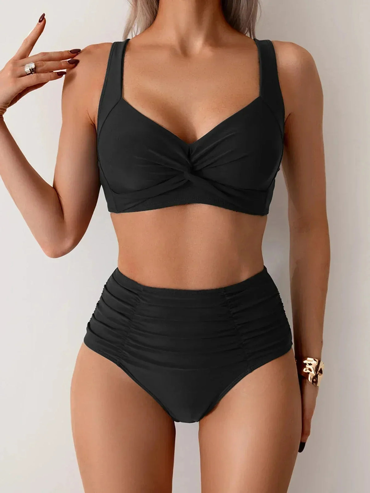 Front view of a black high-waisted bikini with twist-front bralette top and ruched waistband.