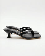 Side view of black strappy thong sandal with square toe and sculptural kitten heel