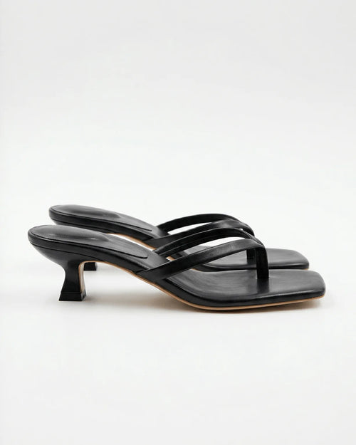 Side view of black strappy thong sandal with square toe and sculptural kitten heel