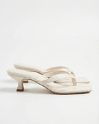 White leather thong sandals showing cutout strap detail and flared kitten heel
