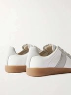 Close-up back view of two sneakers showing the heel tab, suede trim and textured gum outsole