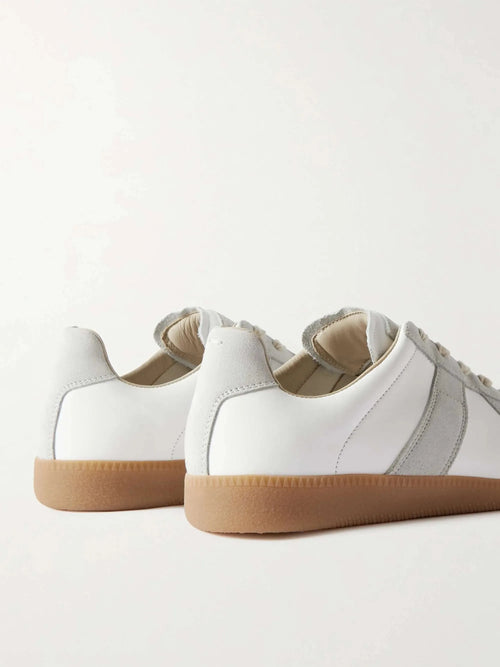 Close-up back view of two sneakers showing the heel tab, suede trim and textured gum outsole