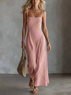 Pink sleeveless maxi dress with square neckline and tan geometric stitching, styled with layered gold necklaces