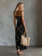 Back view of black sleeveless maxi dress showing square back neckline and crisscross stitched pattern
