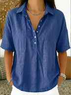 Front detail of a blue linen-style button-up blouse showing the collar and relaxed sleeves