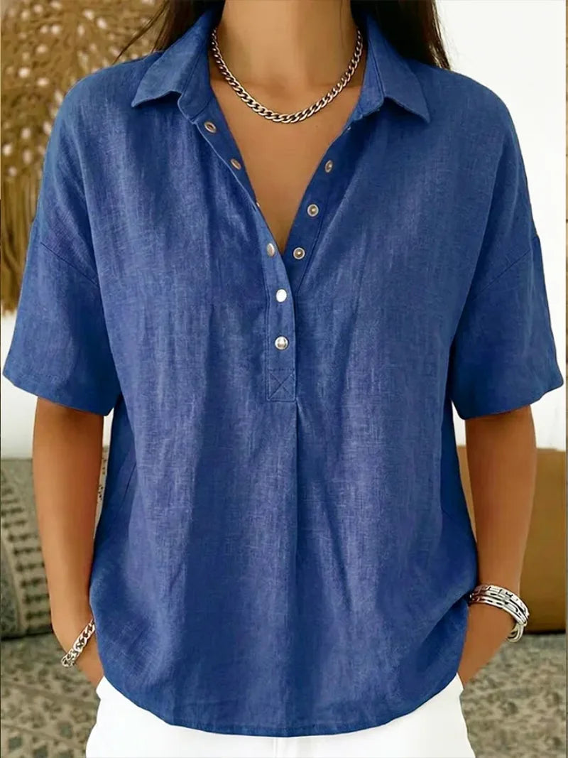 Front detail of a blue linen-style button-up blouse showing the collar and relaxed sleeves