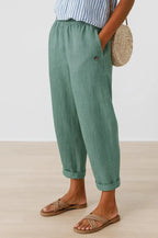 Sage green cropped trousers with cuffed ankle hem, relaxed balloon leg silhouette and side pocket