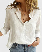 White linen button-down shirt with ruffled collar shown open at the neckline, paired with denim shorts