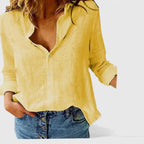 Pale yellow linen button-down shirt with long sleeves rolled at the cuff, worn with blue denim shorts