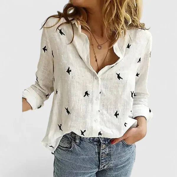 Model wearing an off-white linen shirt with sleeves pushed up, hand resting in denim pocket