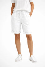 Front view of white linen-look shorts with drawstring waist and turned-up cuffs, shown with a white t-shirt