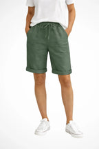 Front view of sage green linen-look shorts with elastic waistband, drawstring tie and rolled hem detail