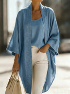 Light wash chambray kimono cardigan and camisole set styled with white jeans and a beige tote bag while walking outdoors
