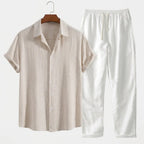 Sand beige textured linen shirt with rolled sleeves styled with crisp white drawstring linen pants on a hanger