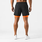 Rear view of black training shorts showing orange compression liner at the hem and seamed back panel