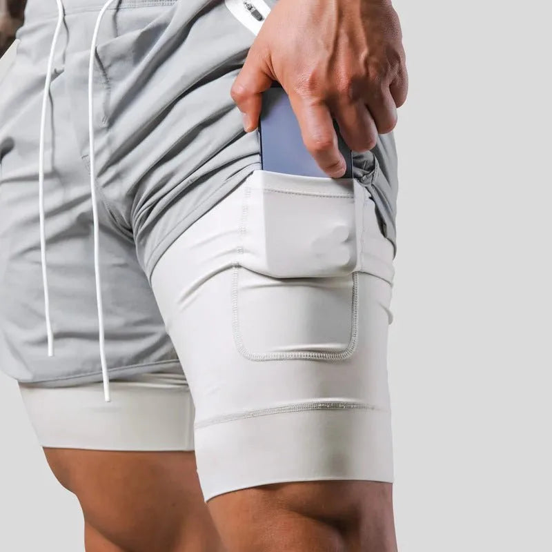 Close-up of hand placing a phone into the thigh pocket of the light grey compression liner