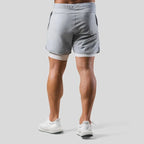 Rear view of light grey training shorts showing white compression liner hem and back seaming