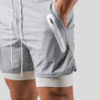 Close-up side view of light grey shorts showing the white zip pocket and contrast liner