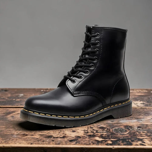Side view of black leather lace-up combat boot with yellow stitched sole on wooden surface