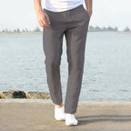 Close side view of light khaki linen pants showing the slim tapered leg near the ankle