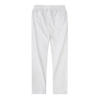 Full rear view of black linen pants paired with a white t-shirt and white sneakers outdoors