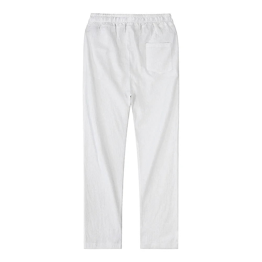 Full rear view of black linen pants paired with a white t-shirt and white sneakers outdoors