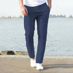 Close view of light khaki linen pants ankle hem resting above white sneakers