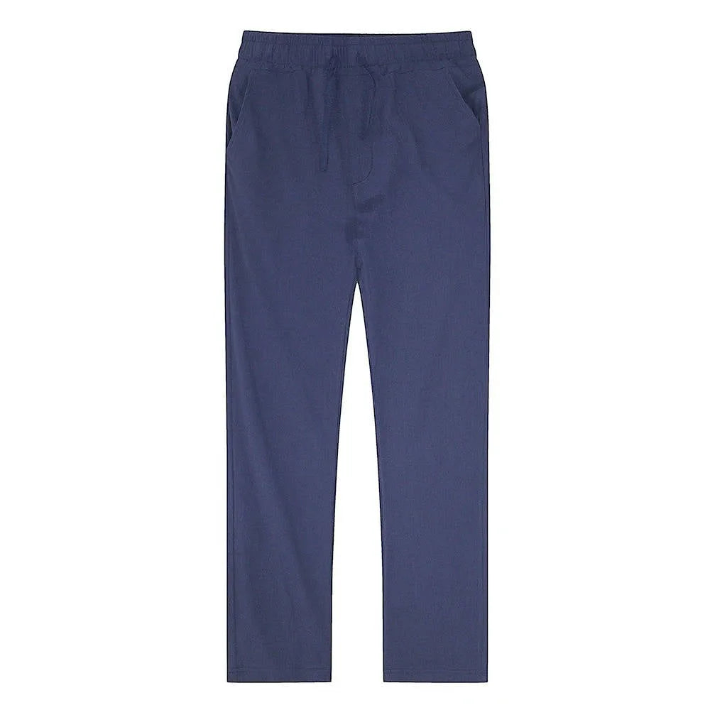 Man standing in black linen pants viewed from the side with hand tucked into the pocket