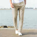 Light khaki linen pants viewed from behind, showing relaxed straight leg and elastic drawstring waistband