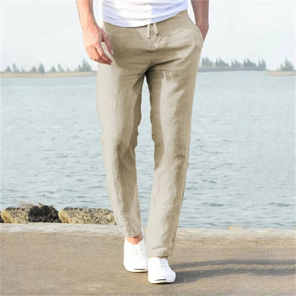 Light khaki linen pants viewed from behind, showing relaxed straight leg and elastic drawstring waistband