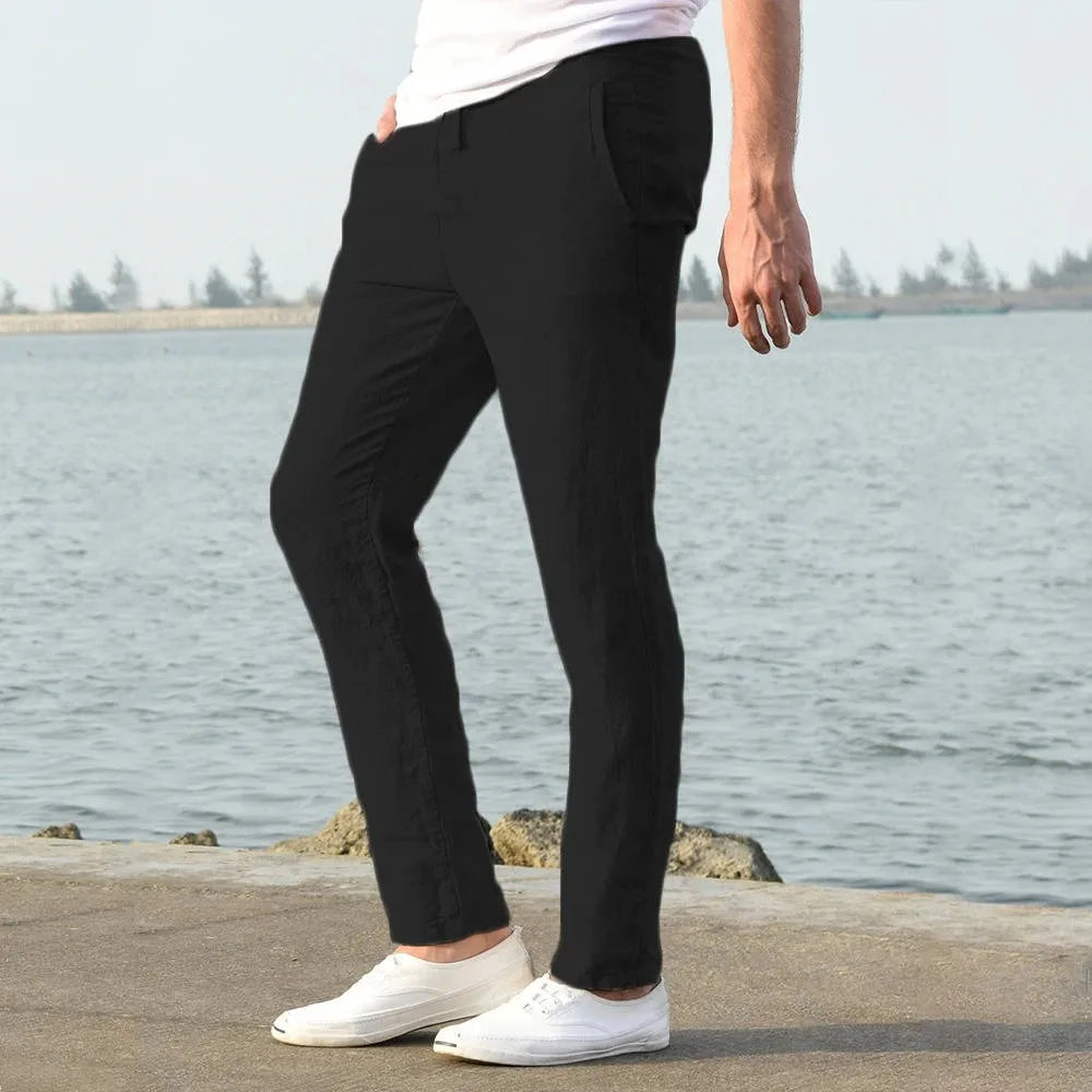 Side profile of black linen pants showing the tapered leg and hand resting in the front pocket